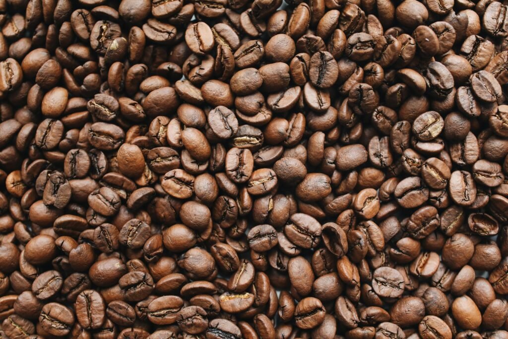 A high-resolution close-up photo of rich, aromatic roasted coffee beans.