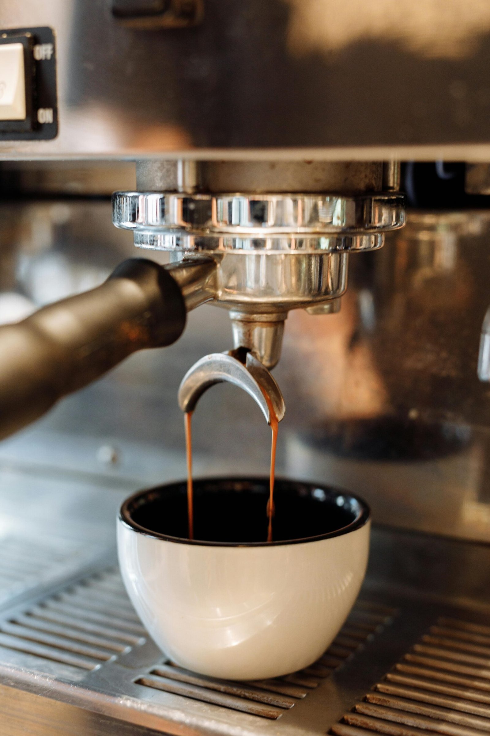 Close-up of espresso brewing into a white cup from a coffee machine. Perfect for cafe themes.