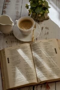 A serene setting featuring an open Bible, coffee cup, and flowers on a wooden table, perfect for introspection.