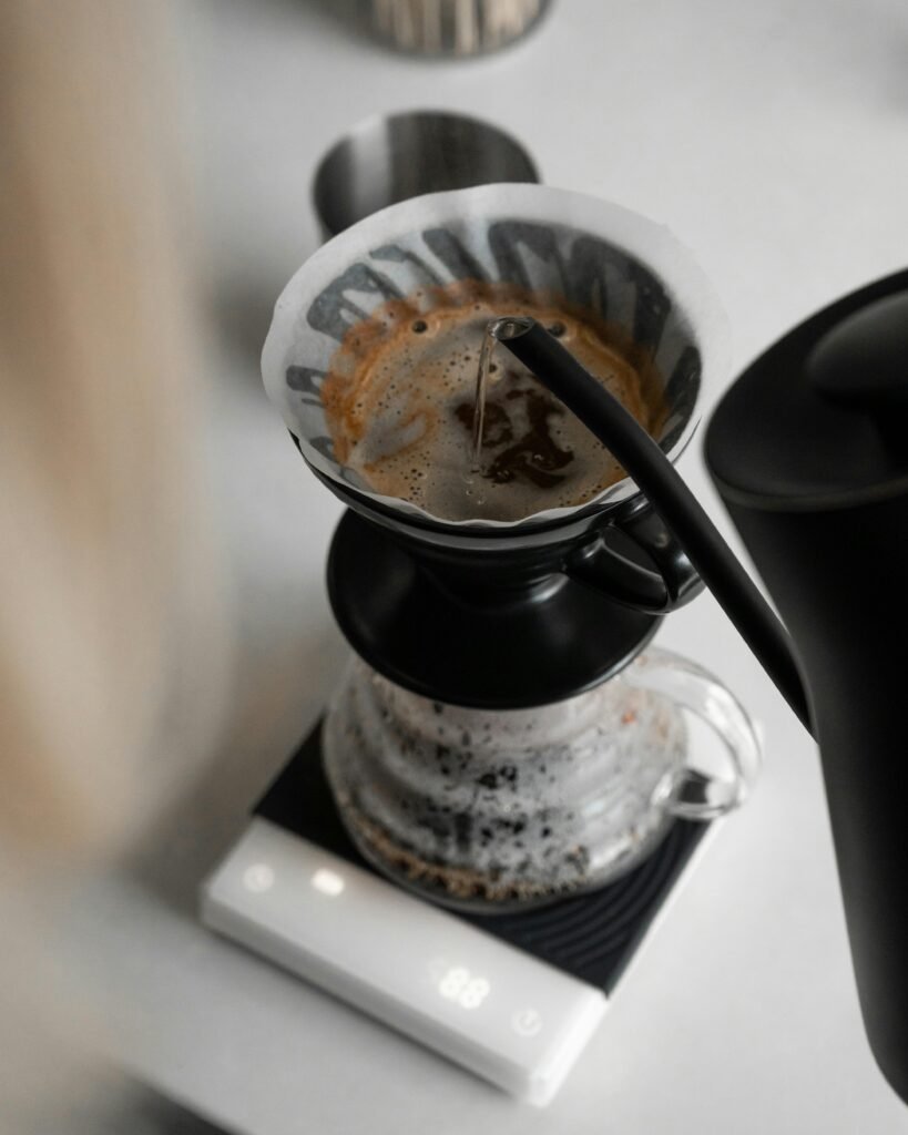 Close-up of a precision pour over coffee brewing process with a kettle and scale.