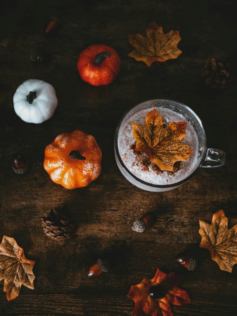 Warm autumn coffee surrounded by decorative pumpkins and leaves, embodying the essence of fall.