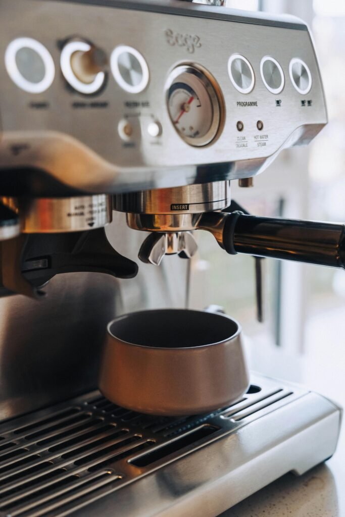 Close-up of a modern espresso machine making a fresh coffee shot indoors.